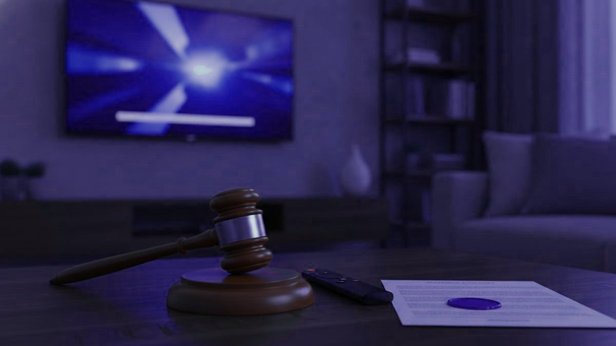 A judge gavel, a streaming remote and a sealed document on a coffee table in front of a TV